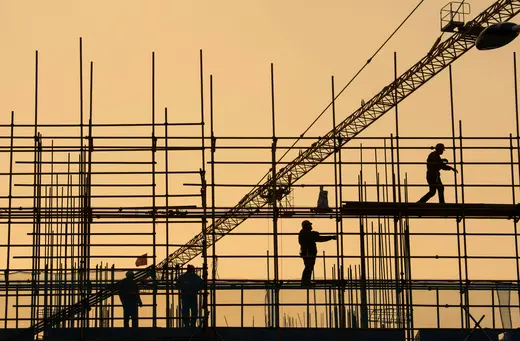 Workers are seen on scaffolding at a construction site in Nantong, Jiangsu province, China, on January 1, 2019.